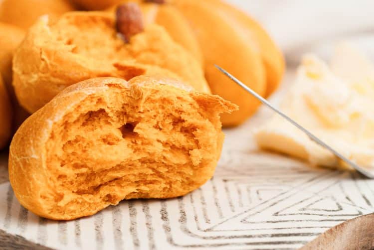 Pumpkin dinner roll pulled apart to show the interior texture.