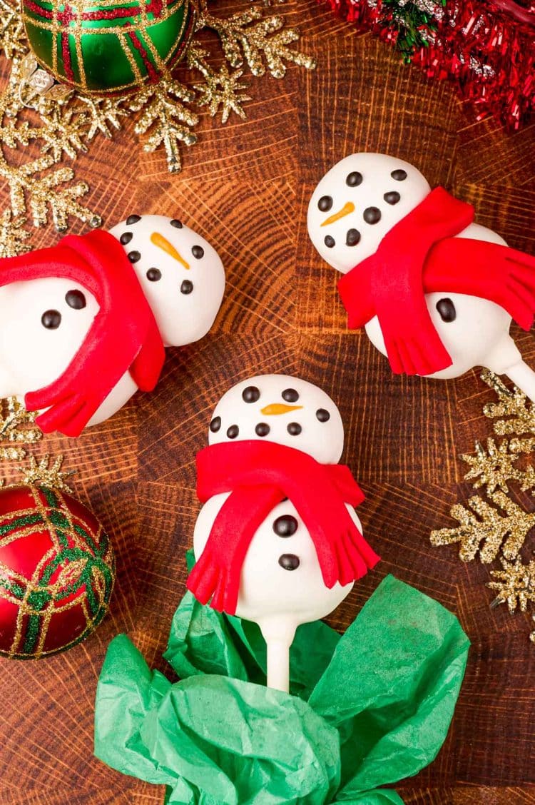Cute snowman cake pops on a wooden table.