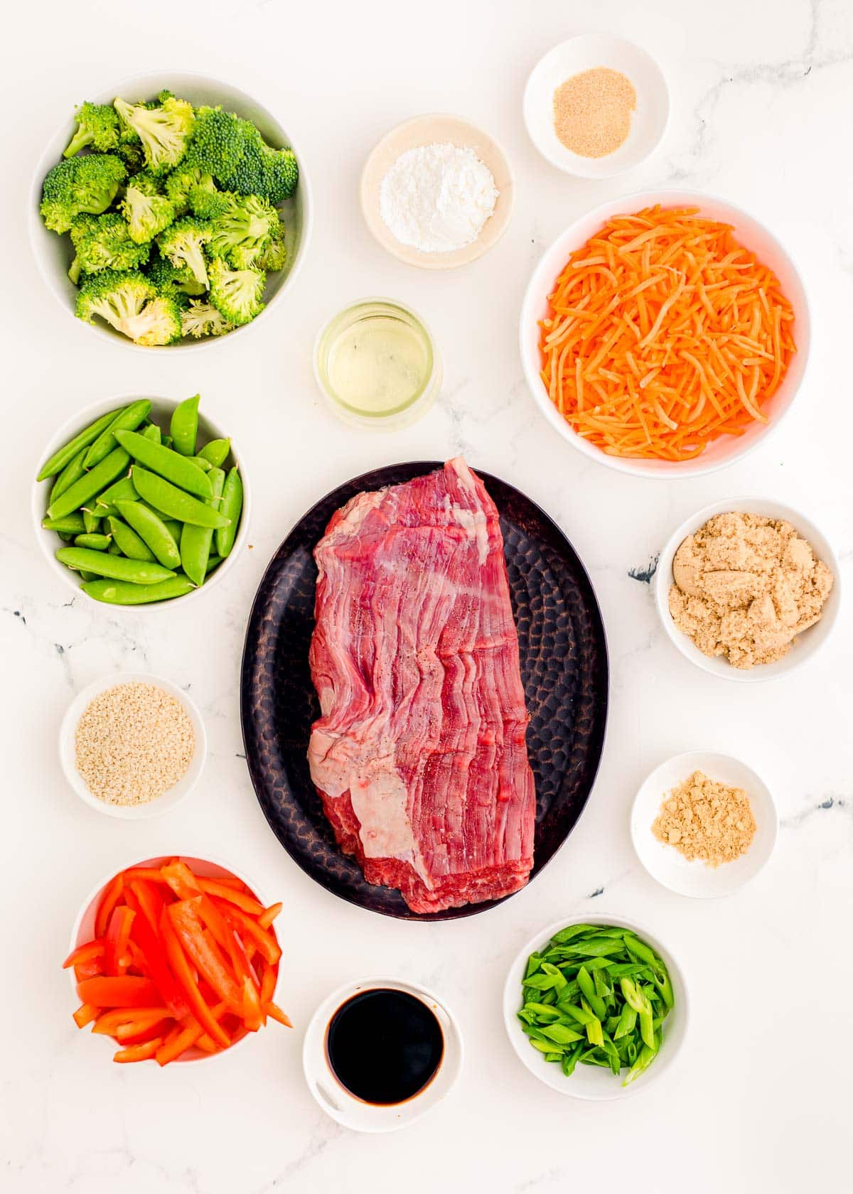 Beef stir fry ingredients on a marble table.