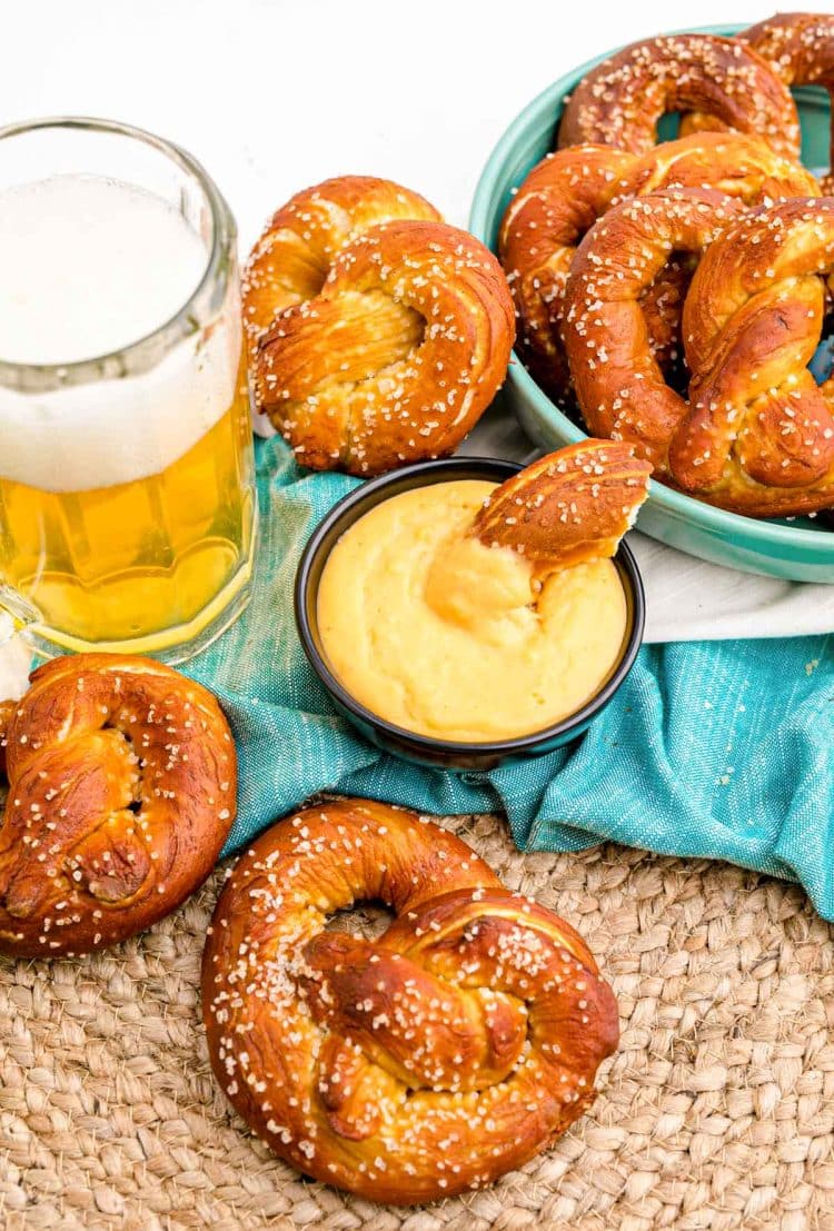 Soft pretzels on a teal napkin with a bowl of beer cheese dip.