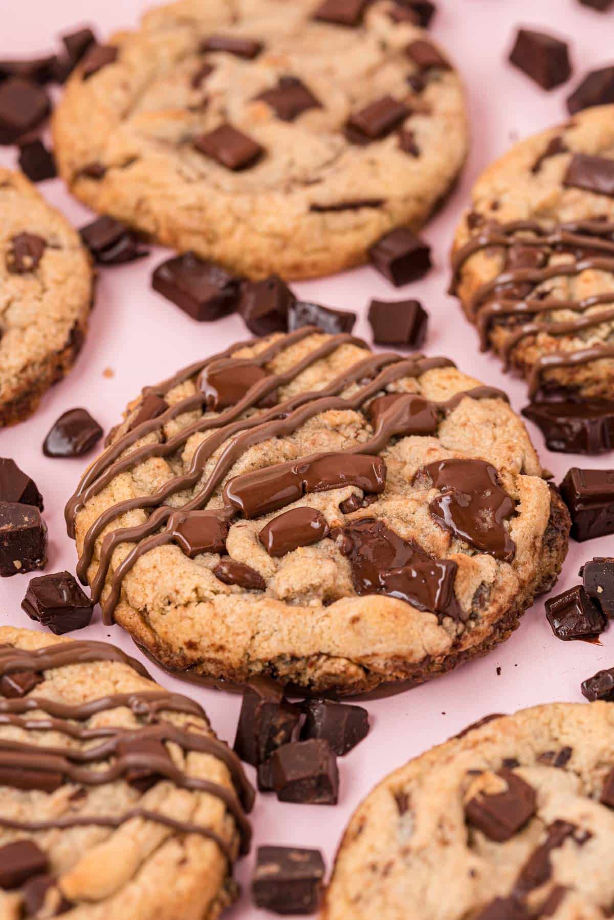 Brown butter chocolate chip cookies on a pink surface.