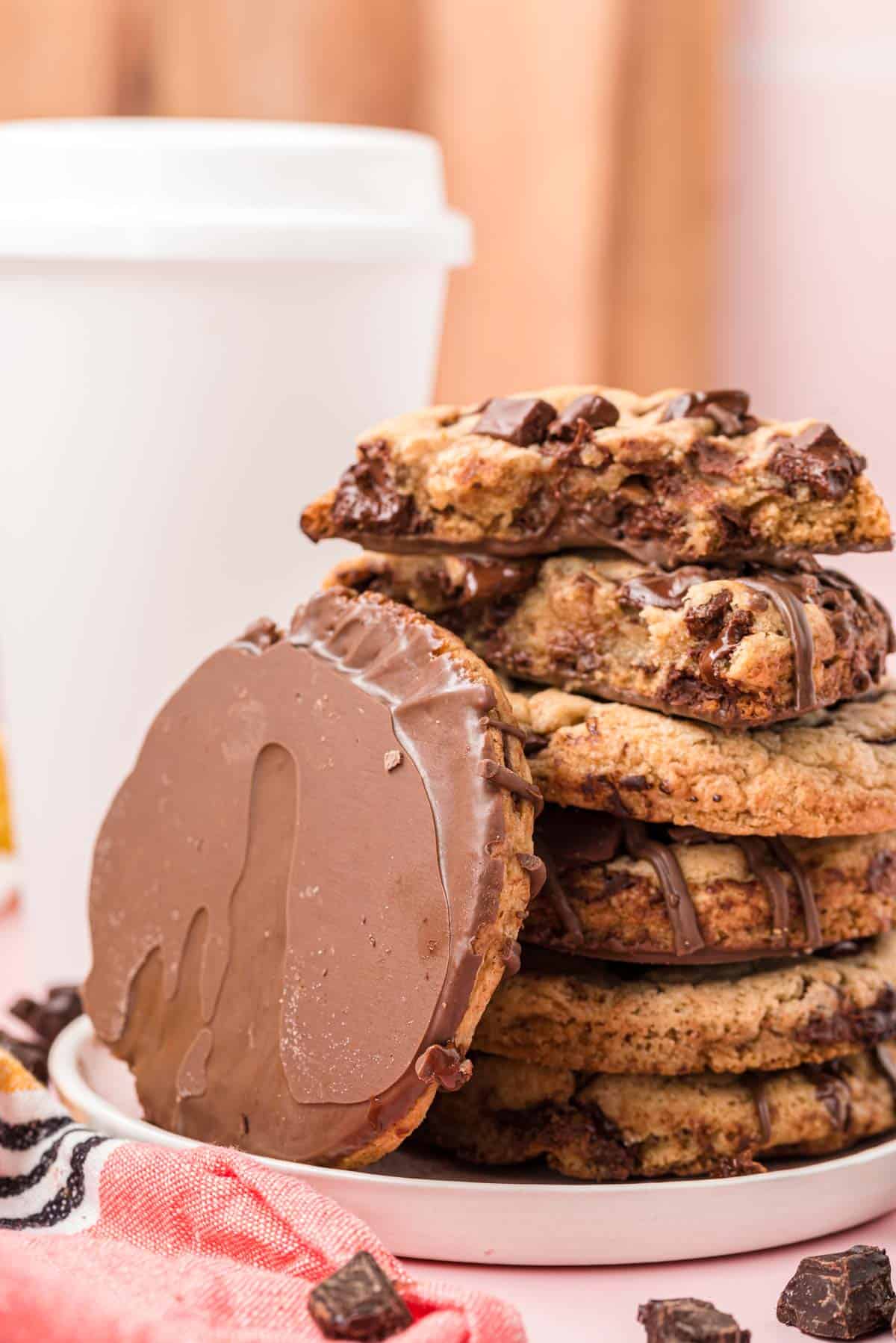 A stack of brown butter chocolate chip cookies on a white plate.