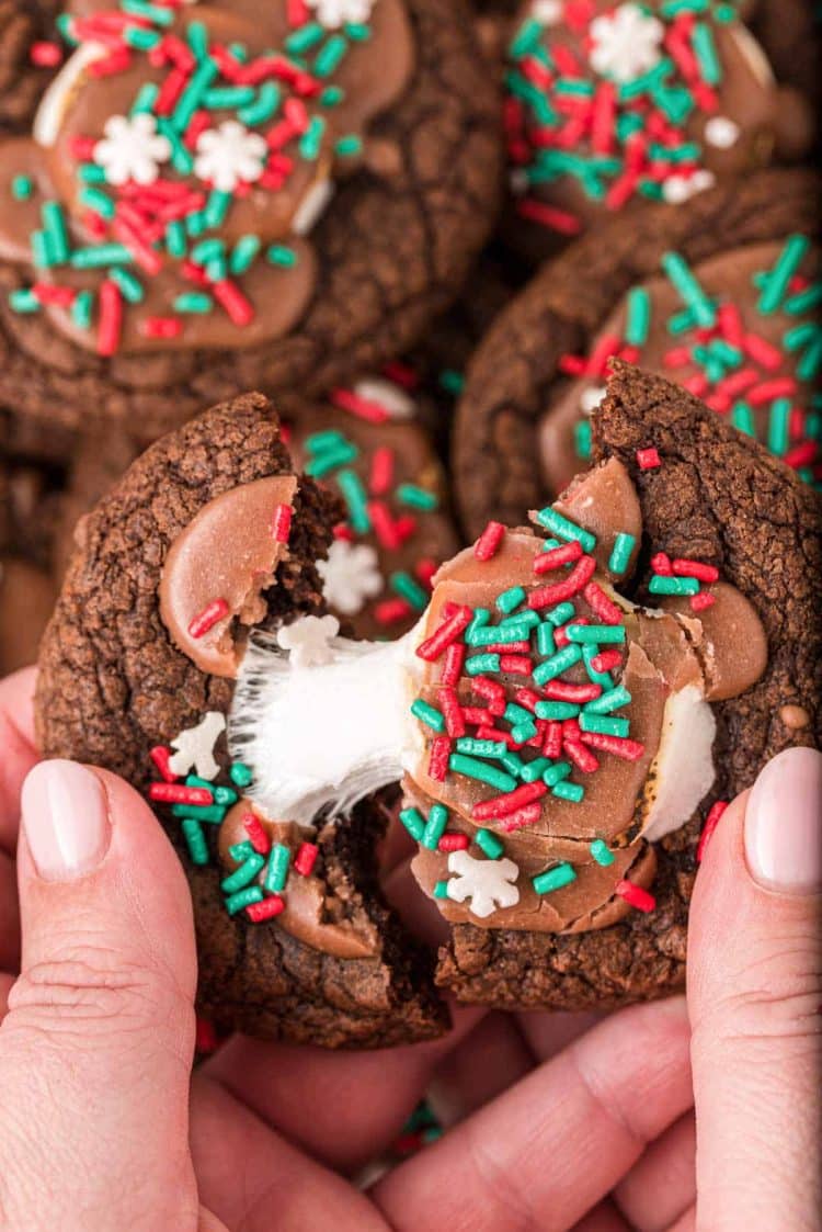 A woman's hand pulling a hot chocolate cookie apart.