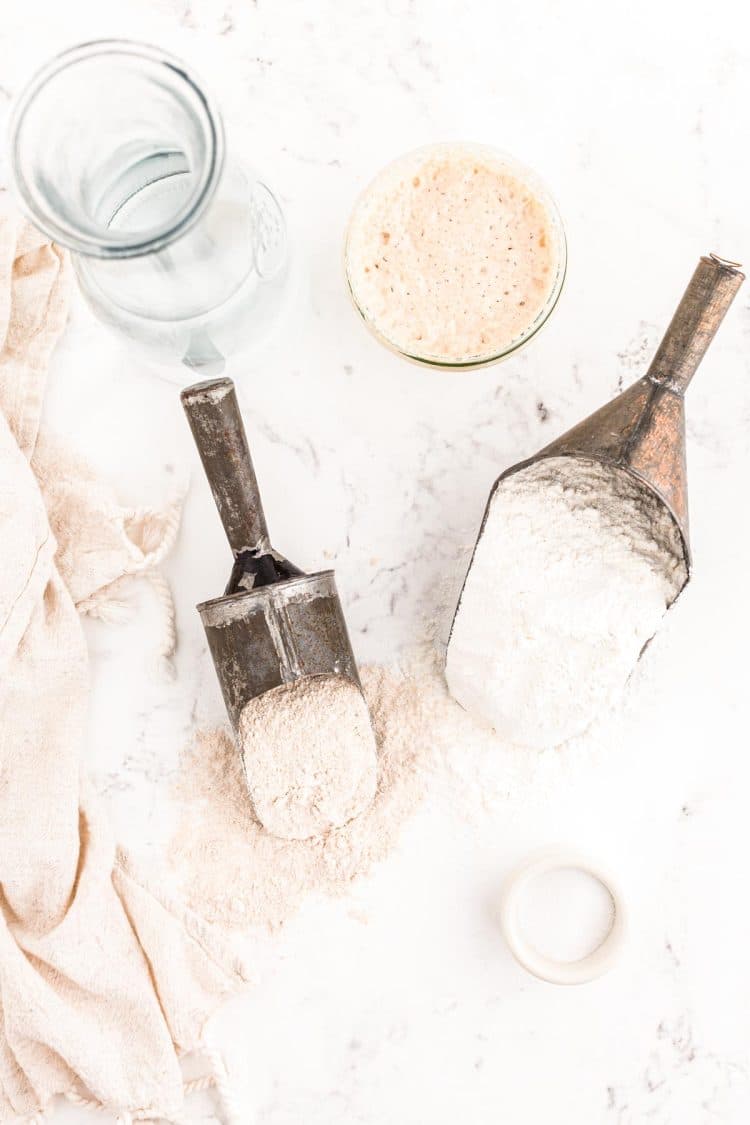 Ingredients to make sourdough bread on a marble surface.