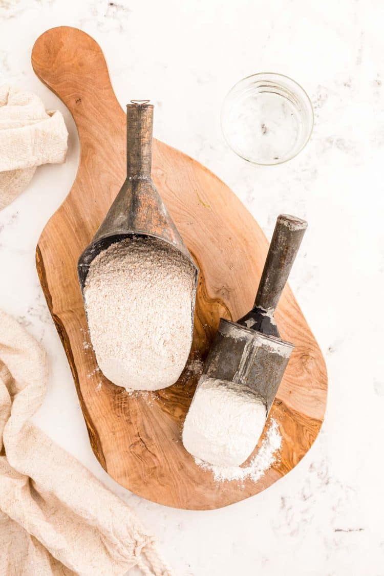 Ingredients to make sourdough starter on a wooden serving board.