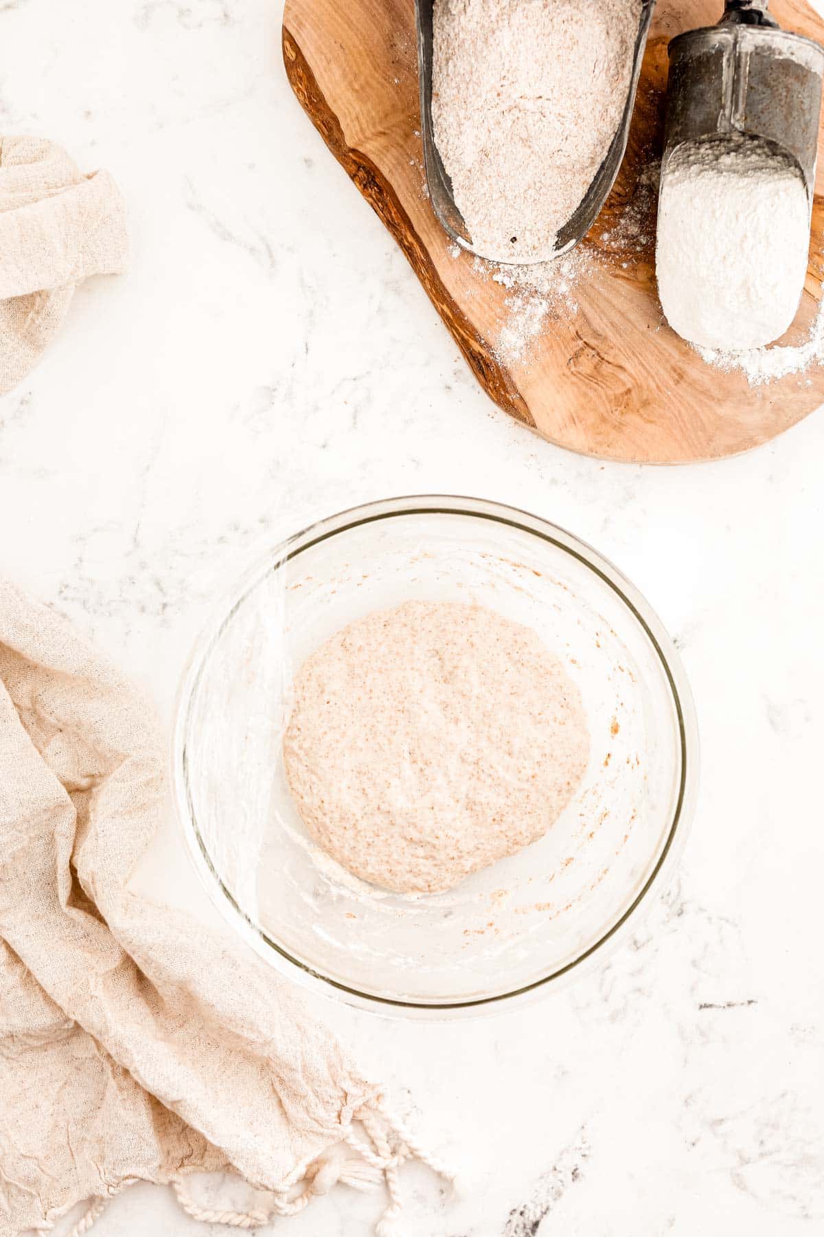 Overhead photo of a sourdough starter in a glass bowl.