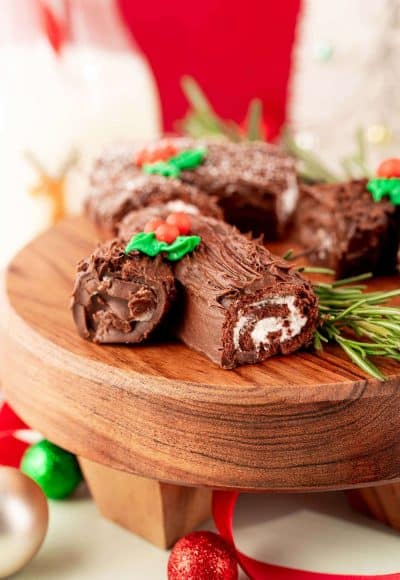 Mini yule log cakes on a wooden cake stand.