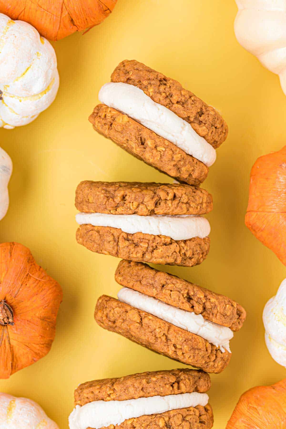 Pumpkin oatmeal cream pies on a yellow surface 