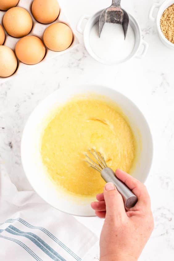 A woman's hand whisking ingredients in a mixing bowl.