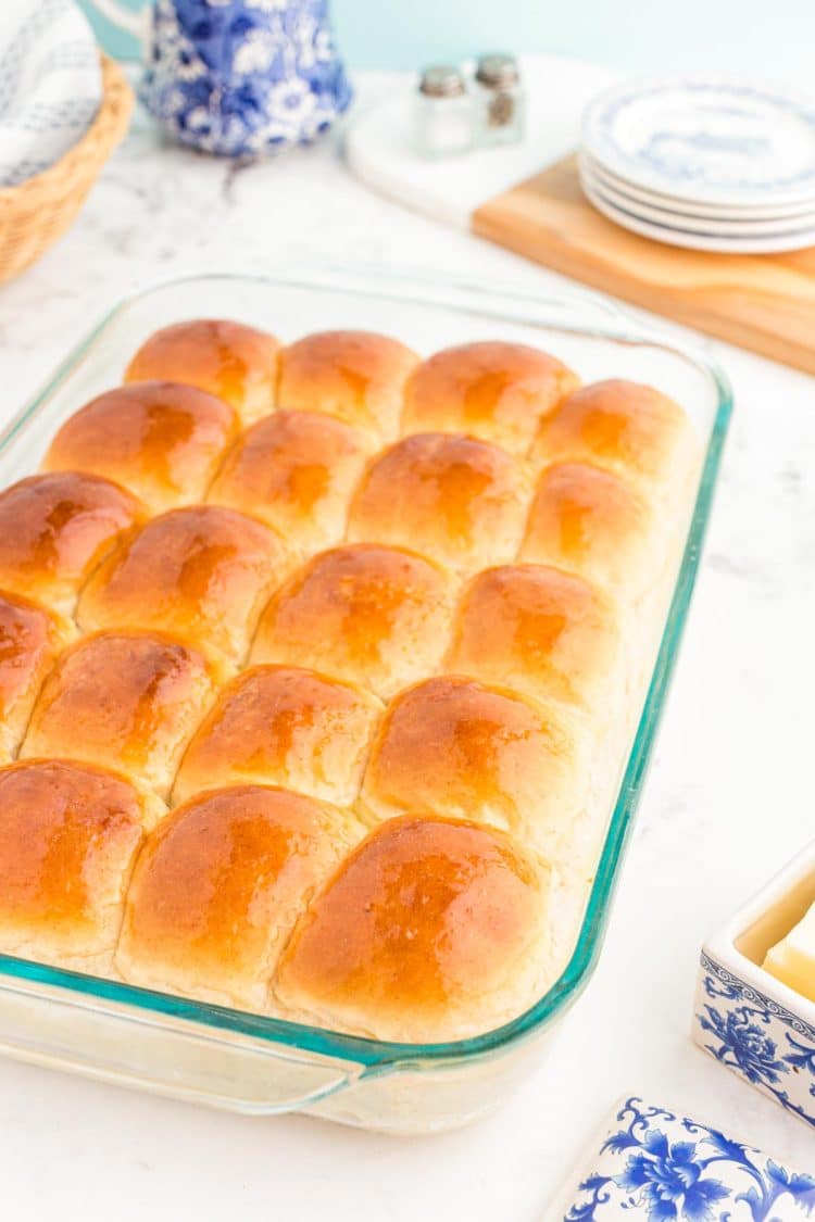A glass baking pan with sourdough dinner rolls in it.