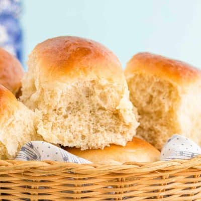 Close up photo of sourdough discard dinner rolls in a basket.