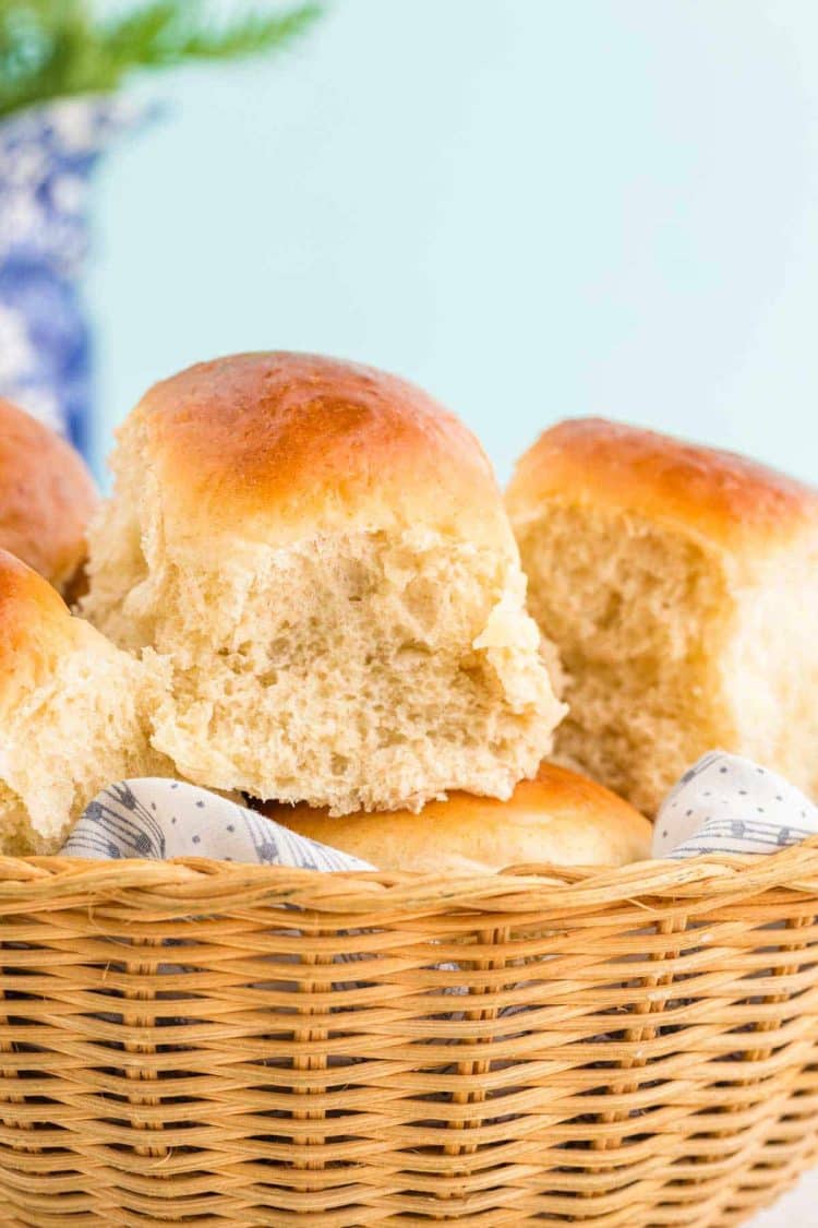 Close up photo of sourdough discard dinner rolls in a basket.