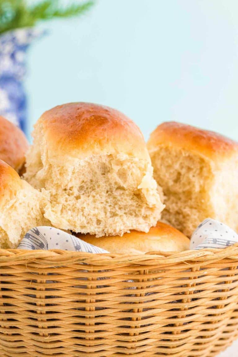 Close up photo of sourdough discard dinner rolls in a basket.