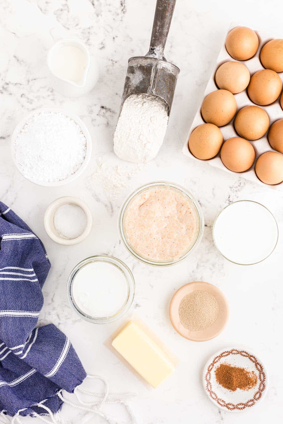 Ingredients to make sourdough donut holes on a white table.