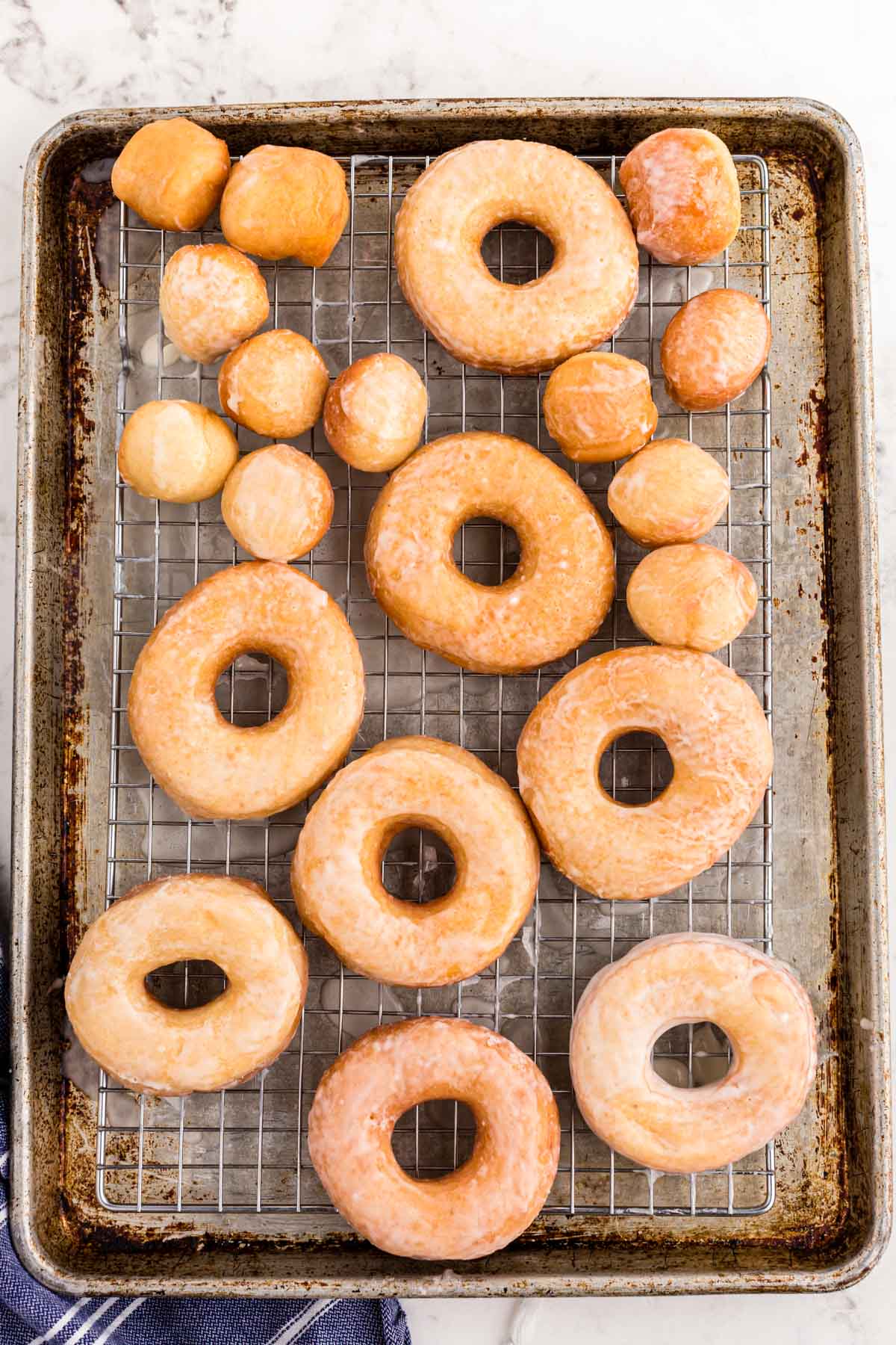 Sourdough donuts on a wire rack on a baking sheet.