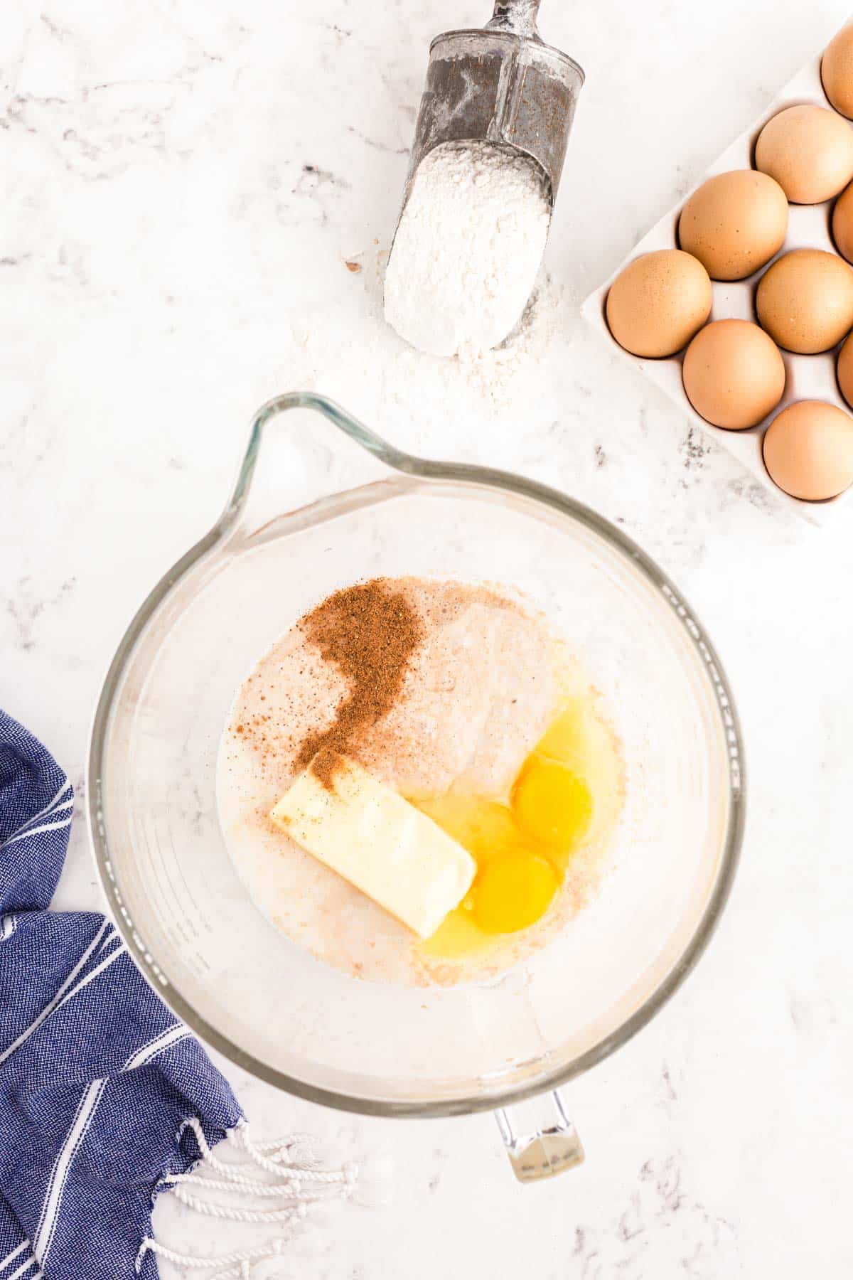 Butter, eggs, and cinnamon added to a bloomed yeast mixture.