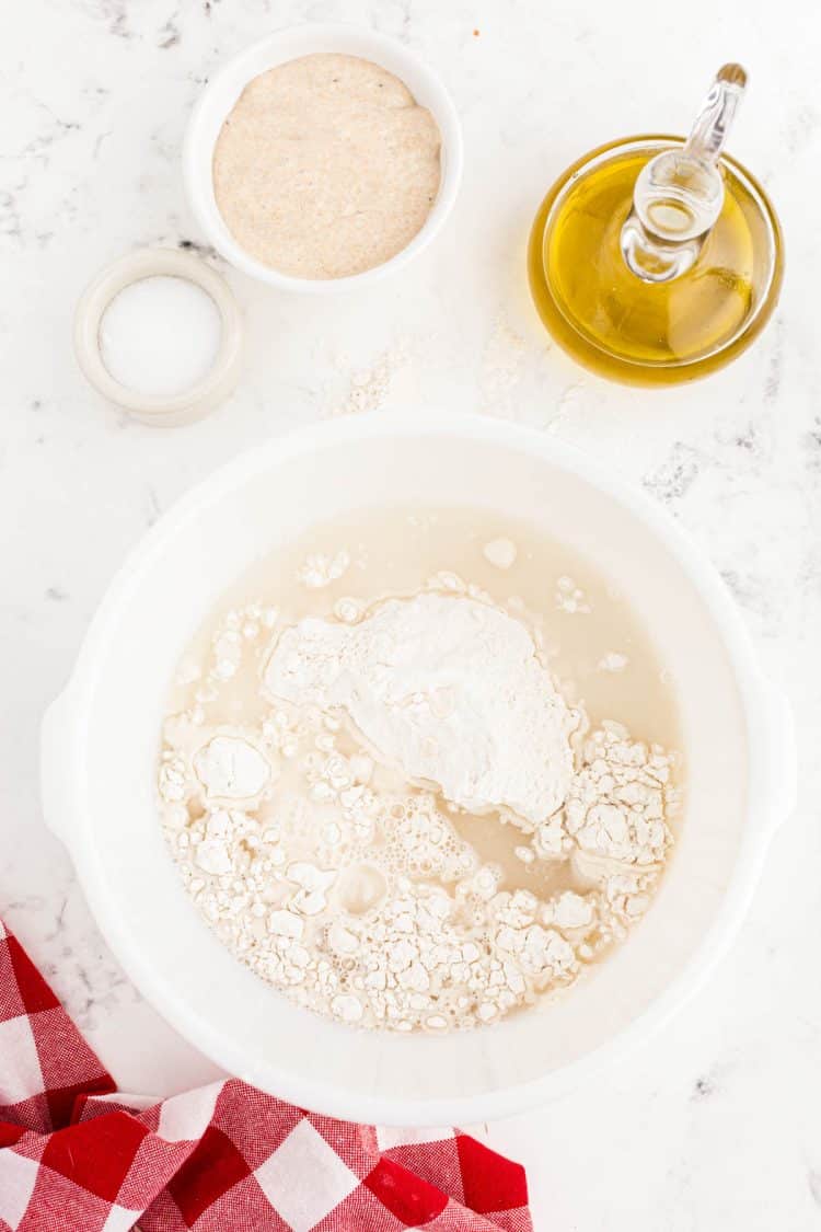 Water and bread flour in a large mixing bowl.