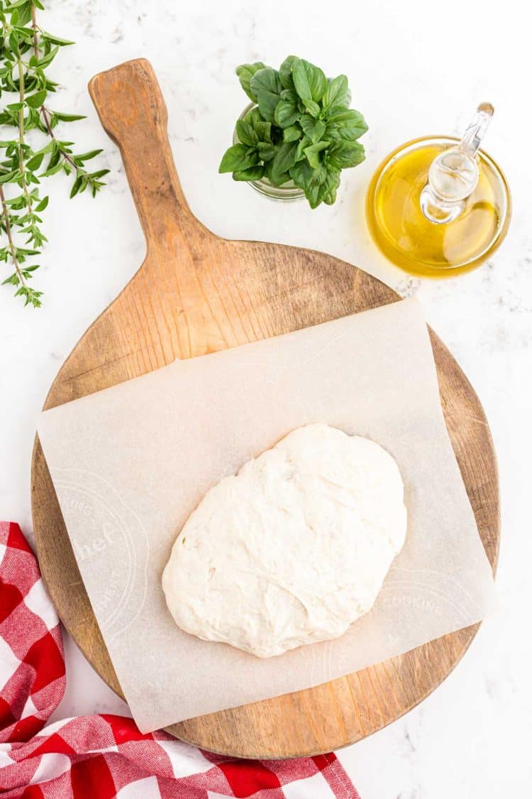 Sourdough bread pizza crust resting on a wooden board.