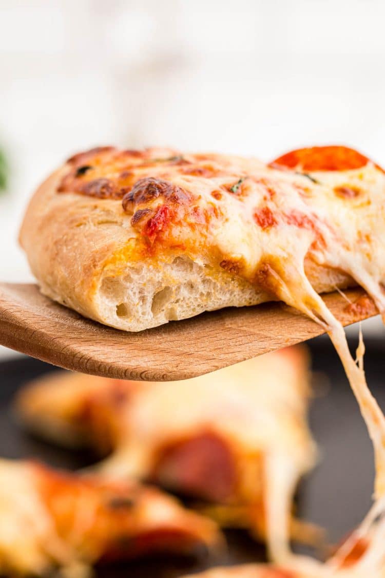 A slice of pizza being pulled away from the pan.