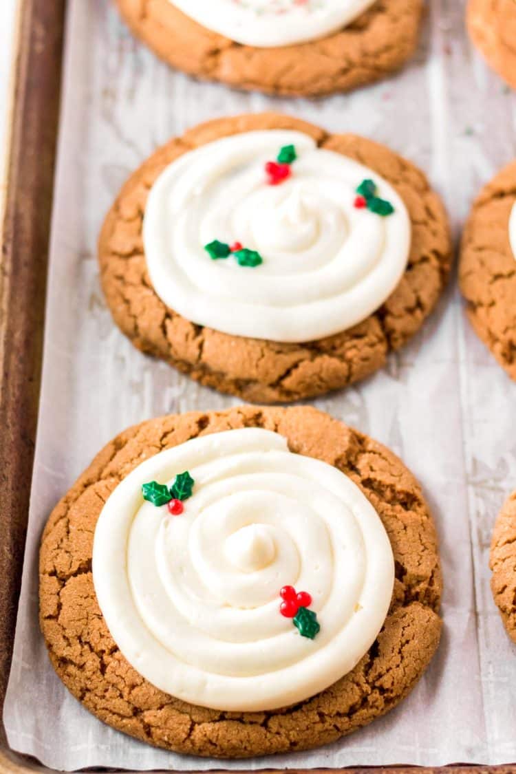 Gingerbread cookies with cream cheese frosting on a baking sheet.