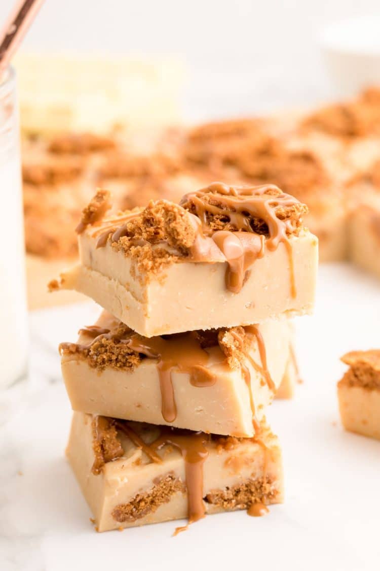 Biscoff fudge stacked three high on a marble surface.