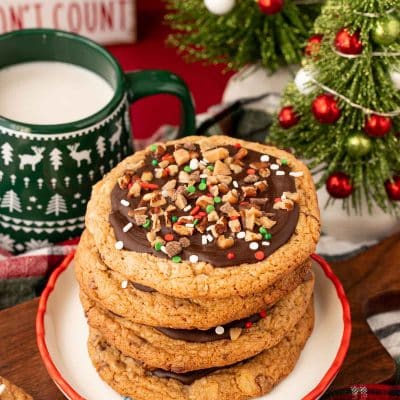 A stack of four Christmas Crack Cookies on a holiday plate.