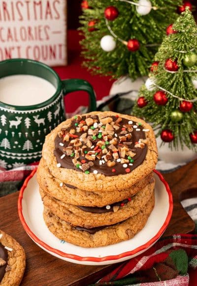 A stack of four Christmas Crack Cookies on a holiday plate.