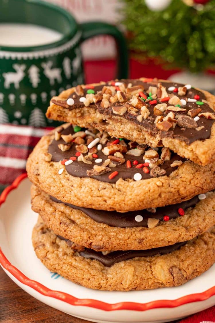 Christmas crack cookies on a holiday plate, the top one has been broken in half to show texture.