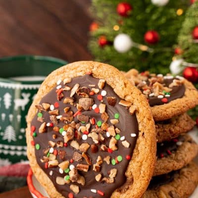 A stack of Christmas Crack Cookies on a plate with one leaving against them.