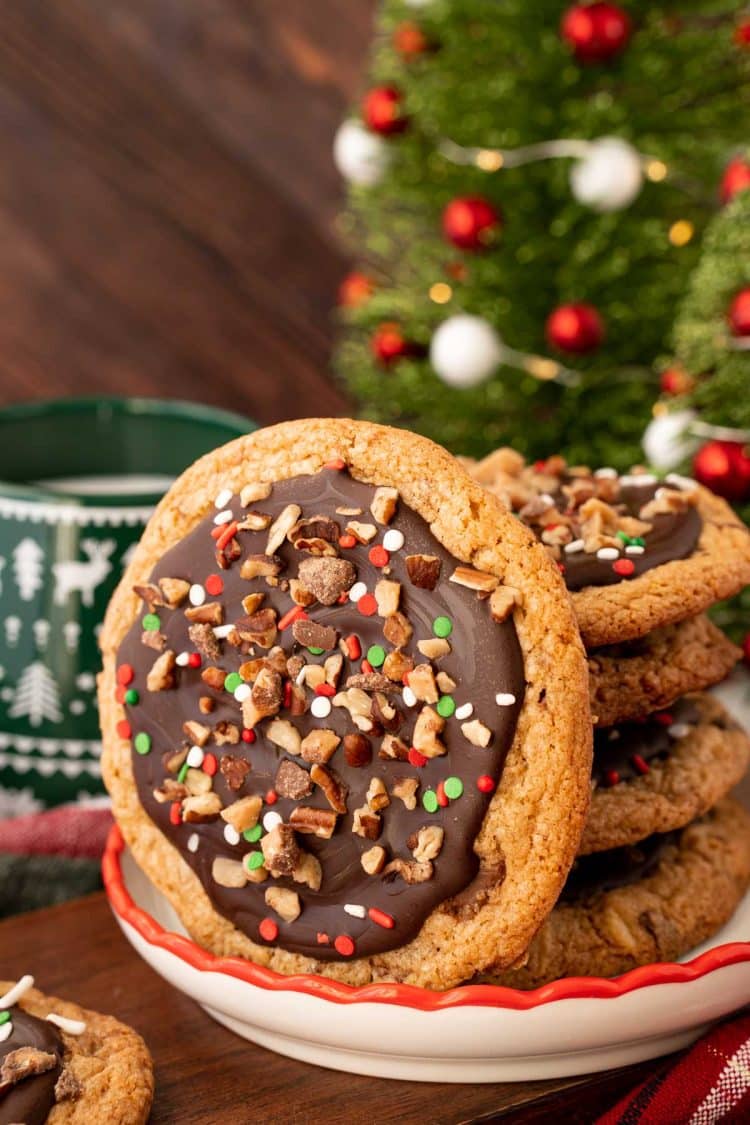 A stack of Christmas Crack Cookies on a plate with one leaving against them.