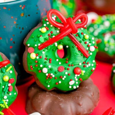 Christmas wreath cookies leaning against a blue mug.