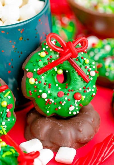 Christmas wreath cookies leaning against a blue mug.