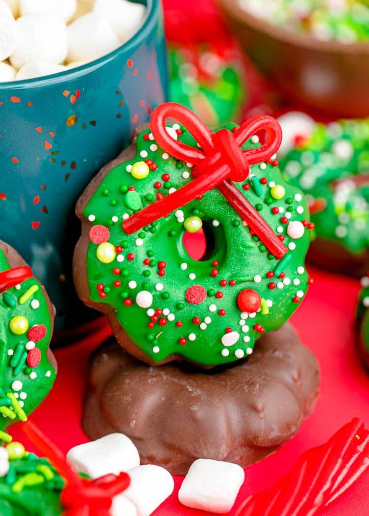 Christmas wreath cookies leaning against a blue mug.