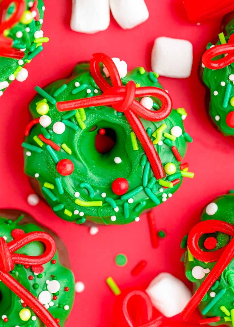 Christmas wreath cookies on a red surface.