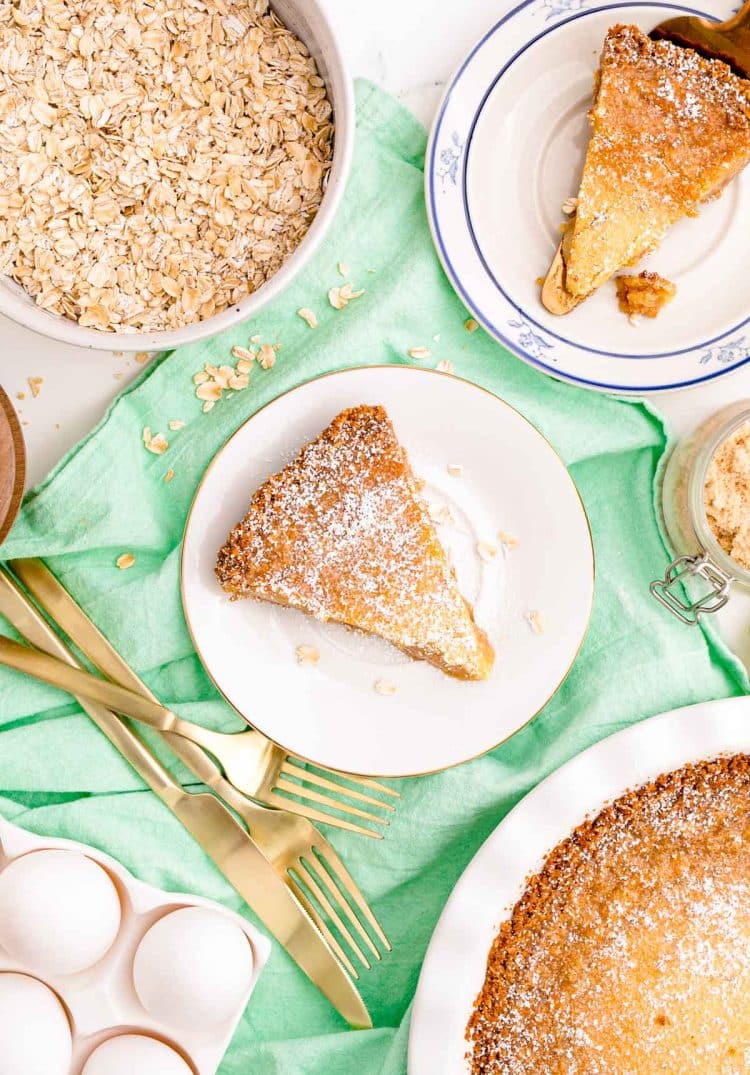 Overhead photo of slices of pie on white plates on a green napkin.