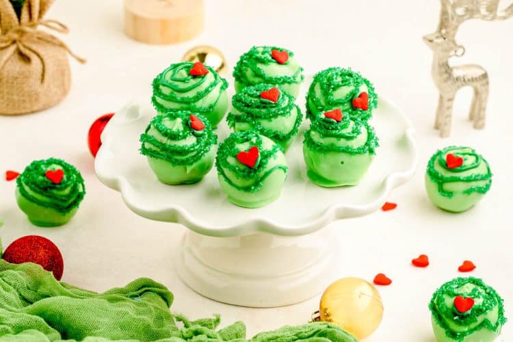 Grinch Cake Balls on a white cake stand.