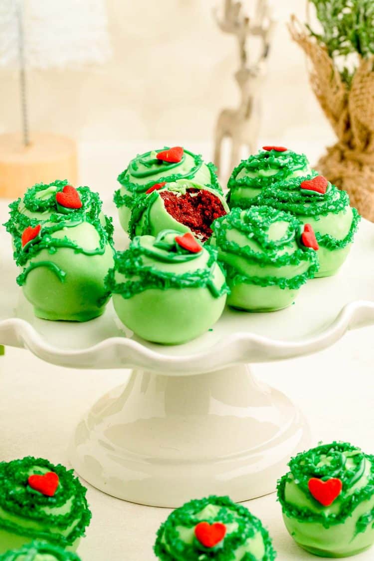 Grinch Cake Balls on a white cake stand.