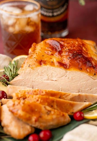 A partially carved glazed turkey breast on a platter.