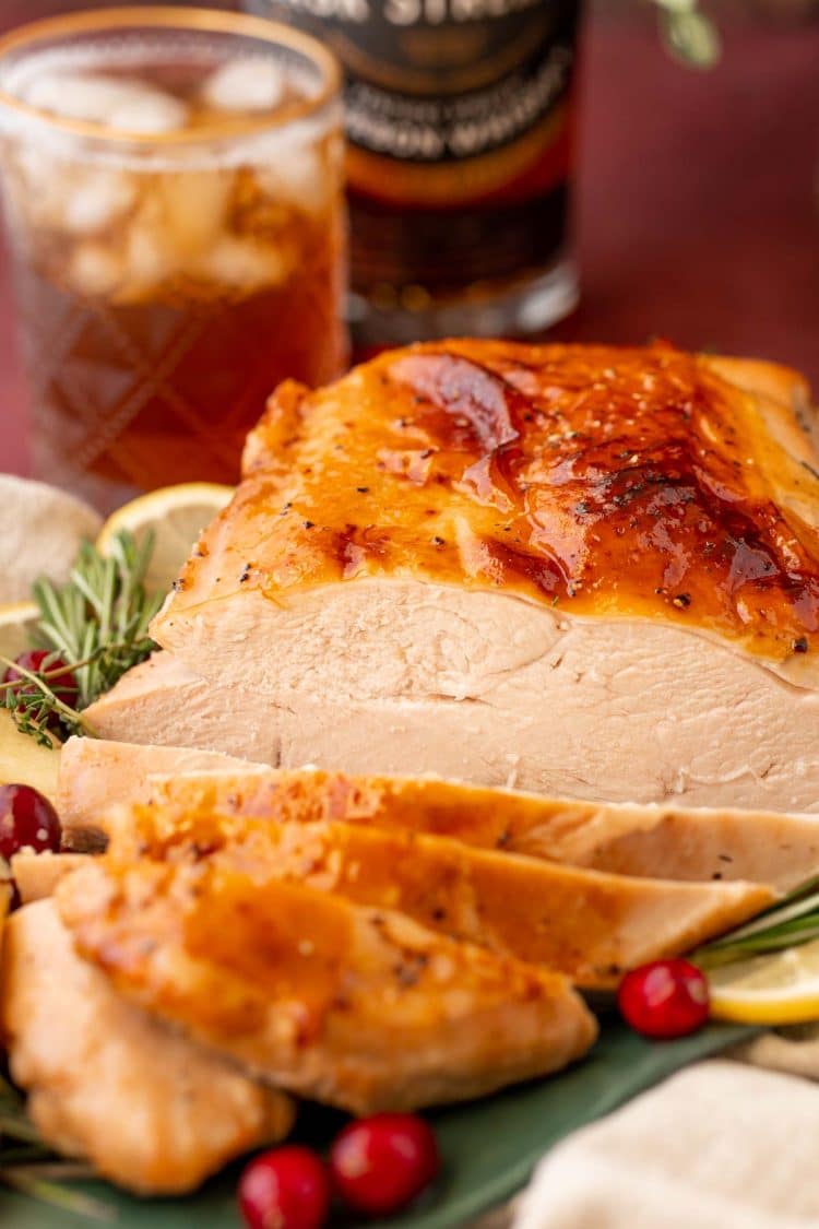 A partially carved glazed turkey breast on a platter.