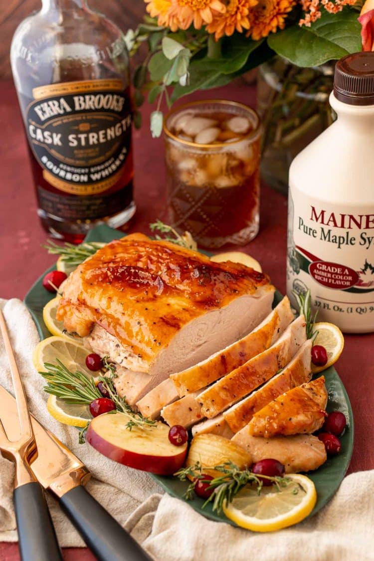 A partially carved glazed turkey breast on a platter.