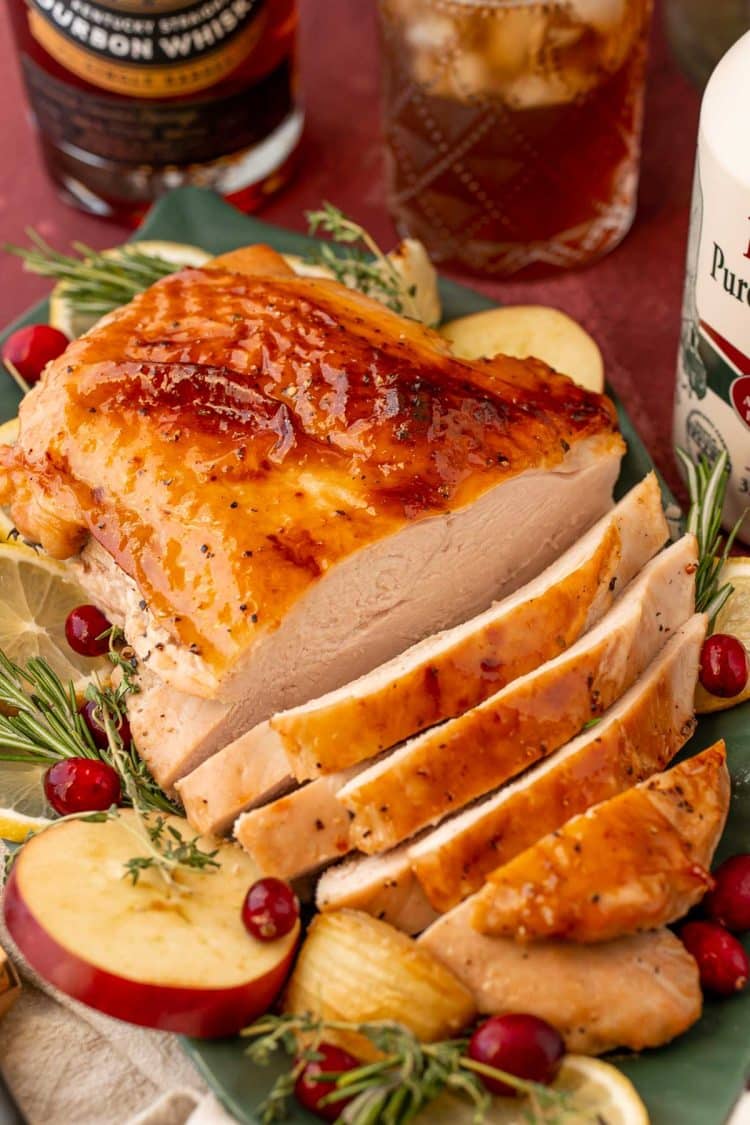 A partially carved glazed turkey breast on a platter.