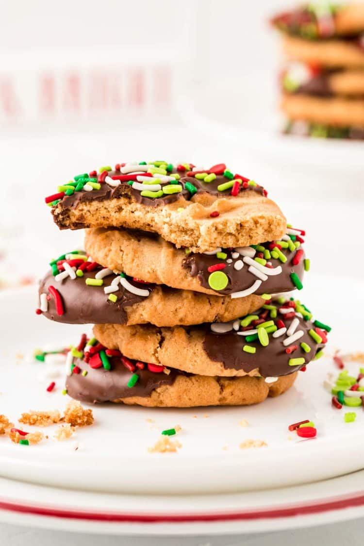 A stack of peanut butter Christmas cookies on a white plate.