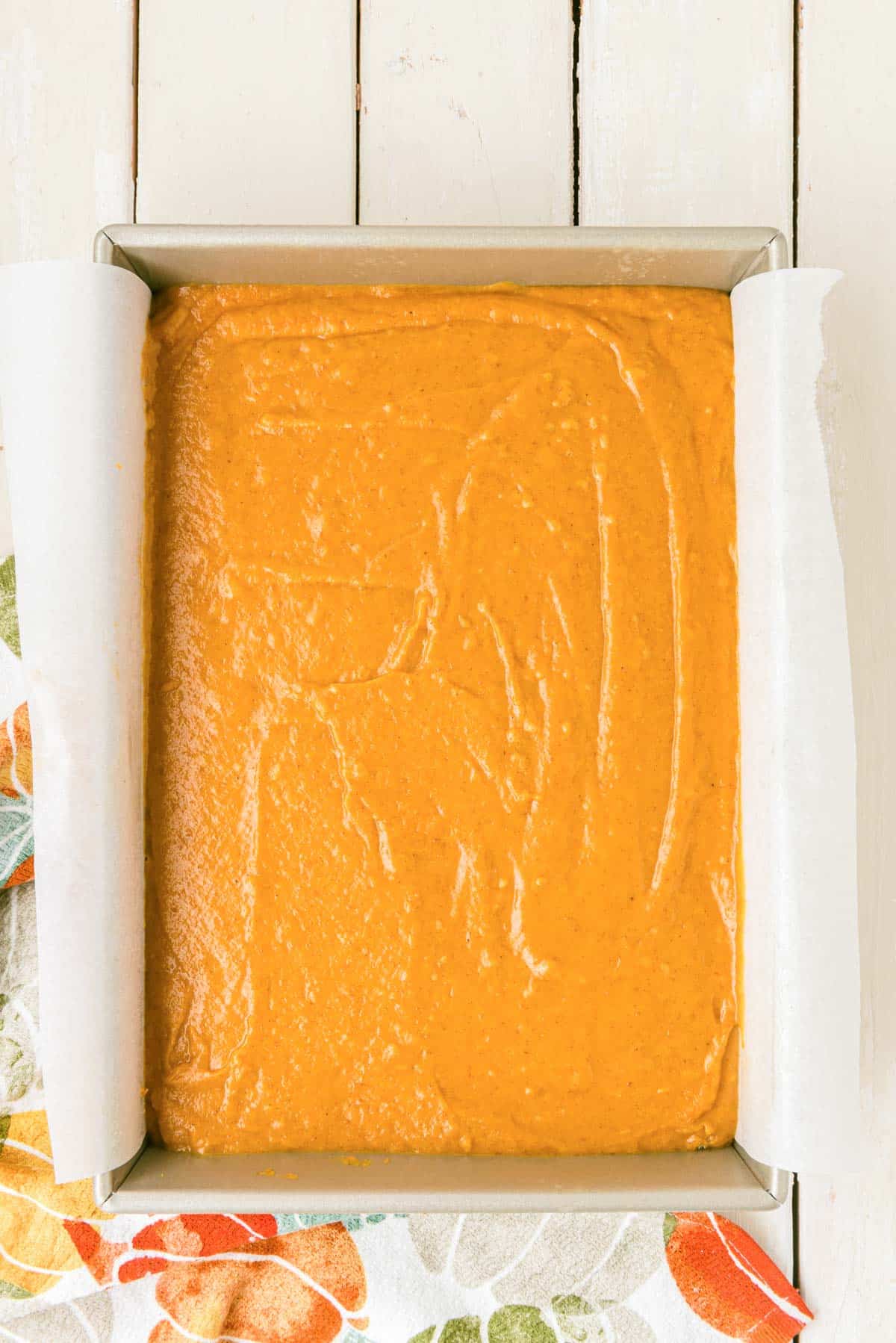 Pumpkin cake batter in a pan ready to bake.