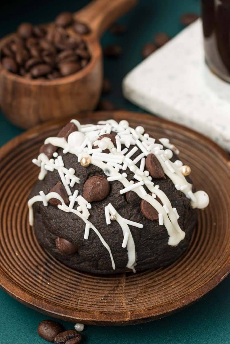A Stuffed peppermint Mocha Cookie on a wooden plate with coffee beans in the background.