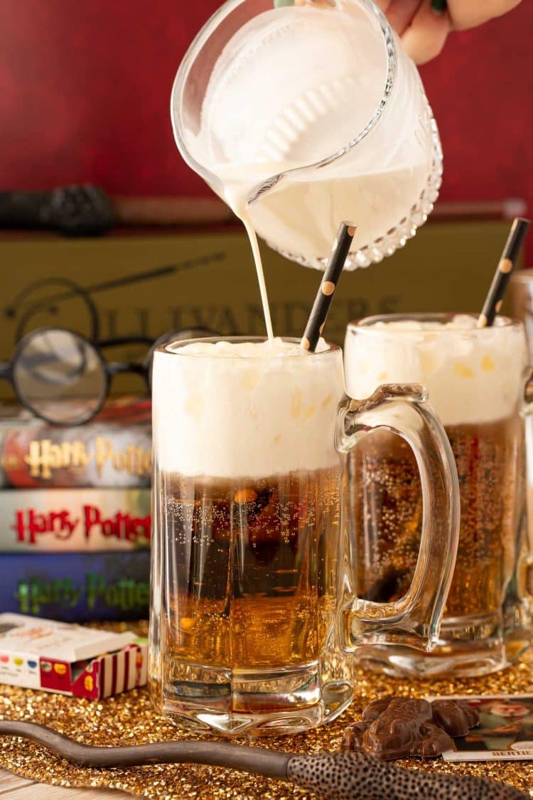 Heavy cream being poured over cream soda to make butterbeer.