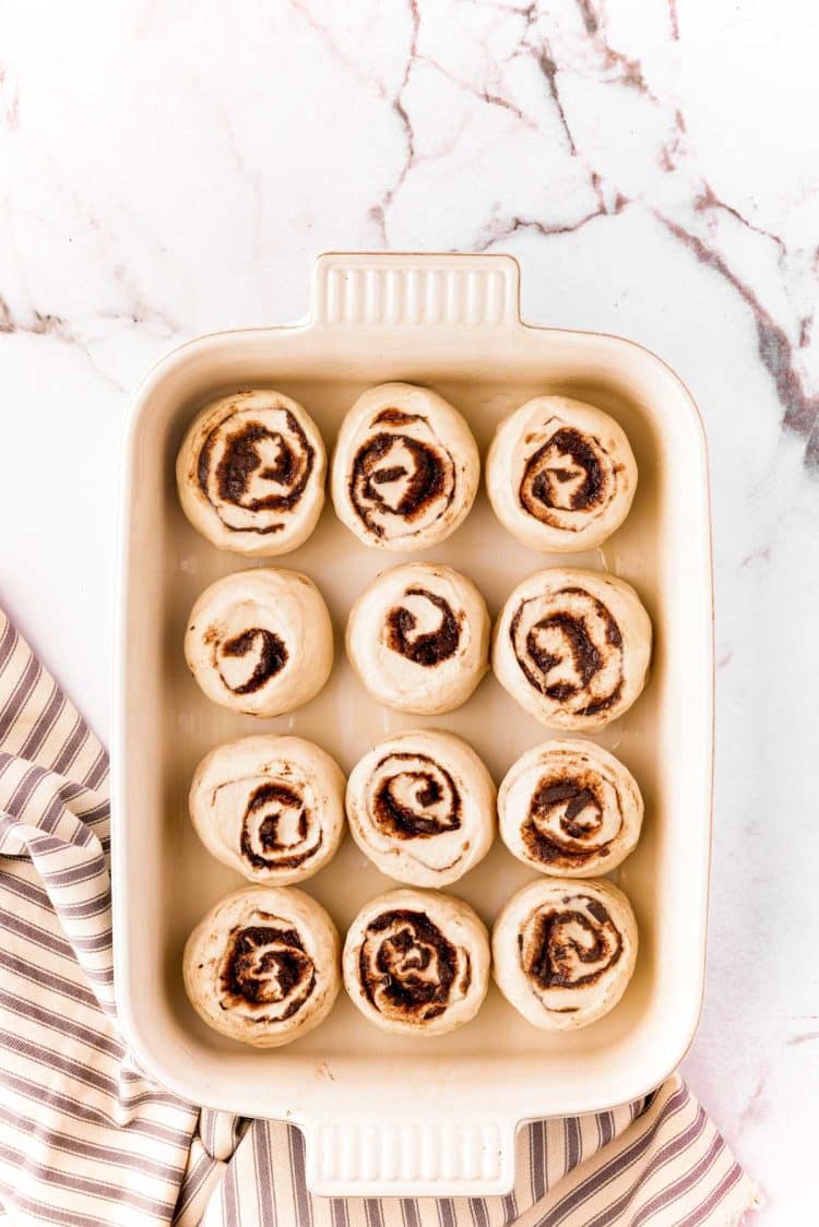 Cinnamon rolls that have been sliced in a baking dish to rise.