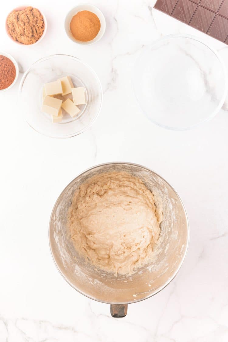 Dough for cinnamon rolls being prepared in a mixing bowl.