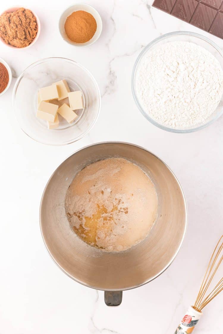 Milk, yeast, sugar, salt, and egg in a stand mixer bowl.
