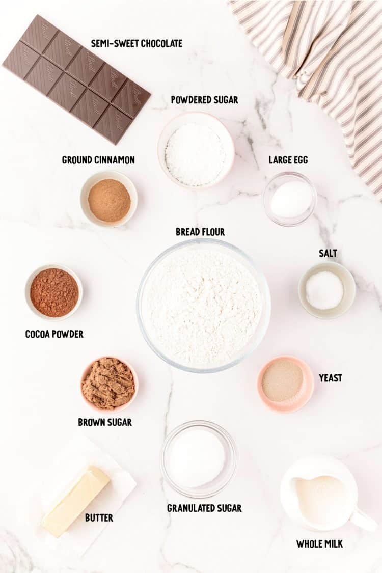 Ingredients to make chocolate cinnamon rolls on a marble counter.