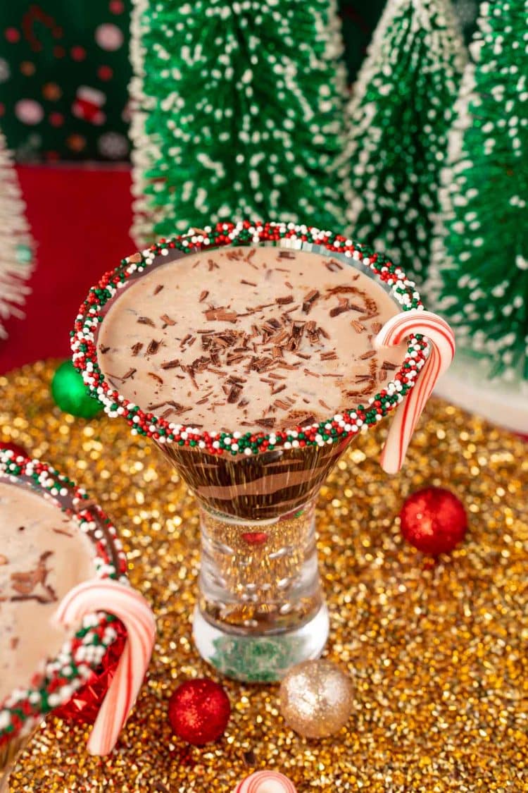 Peppermint Chocolate Martini on a gold surface with holiday decorations around it.